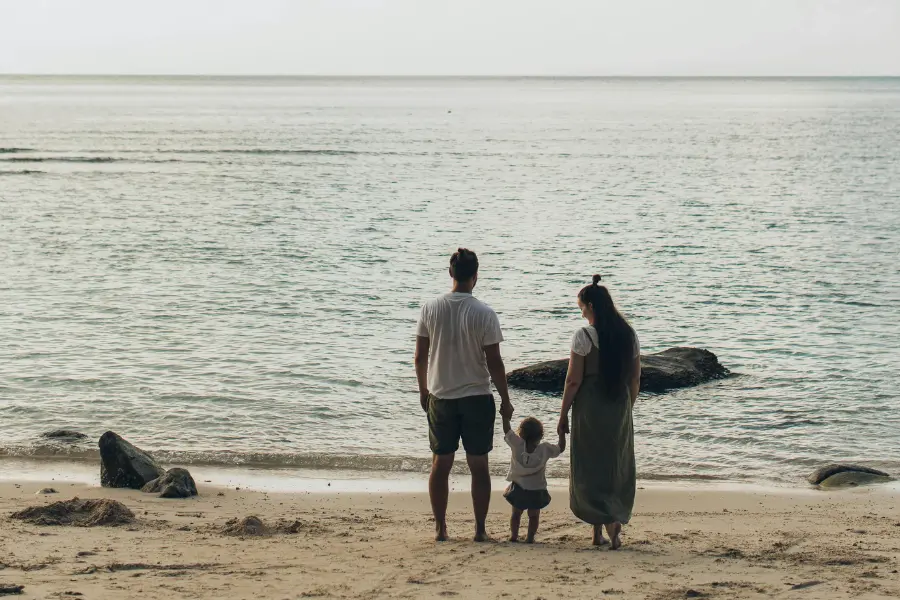 View of a family of 3 vacationing on the beach