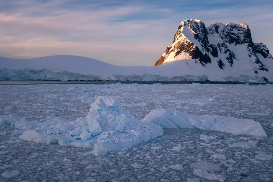 View of snow-covered Antarctic mountain and sea ice.